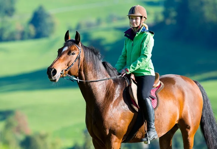 Teen woman having a relaxed riding on her horse in the countryside