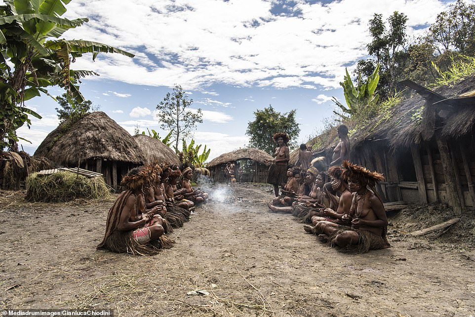 A cultural meeting takes place between the women and children of the tribe as a fire smokes around them. During the feasts women are made to wait their turn