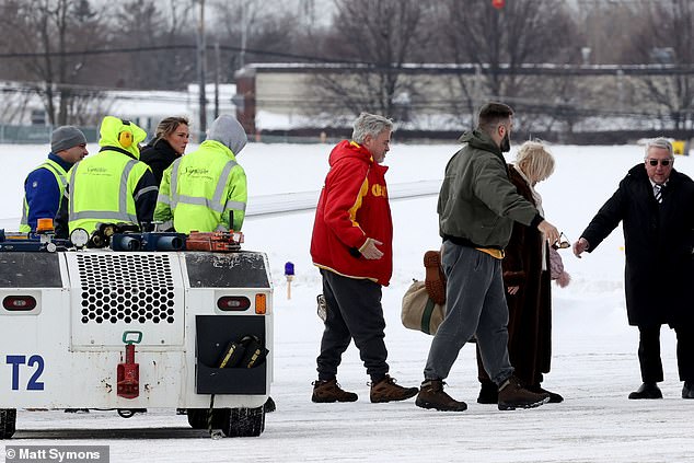 Jason, Kylie and family patriarch Ed - wearing bright red Chief's starter jacket and a jersey bearing his younger son's No. 87 - all trudged across the snowy airfield