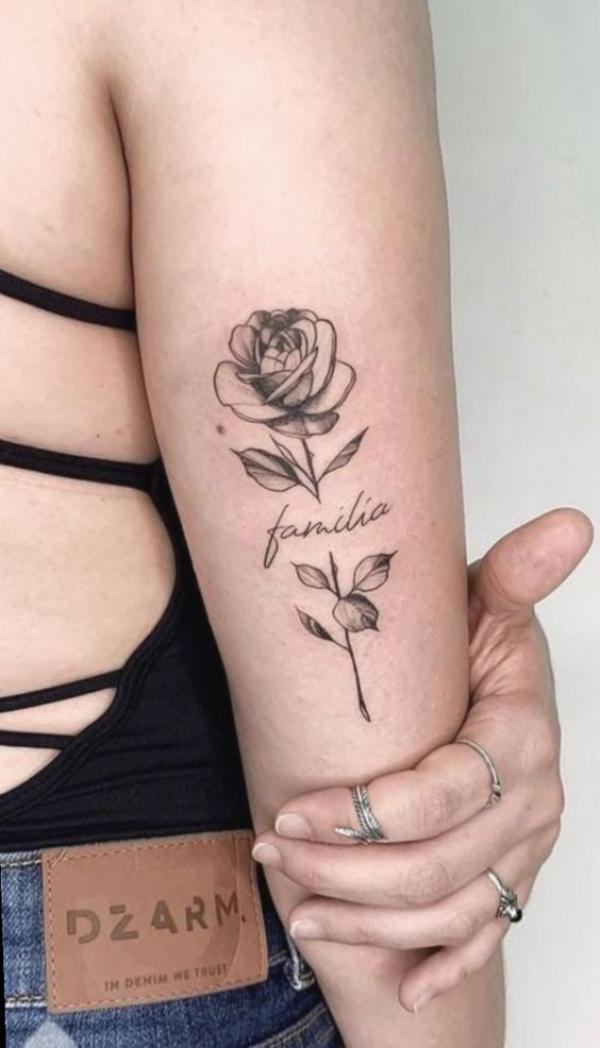 Black and grey rose with word familia back of arm tattoo