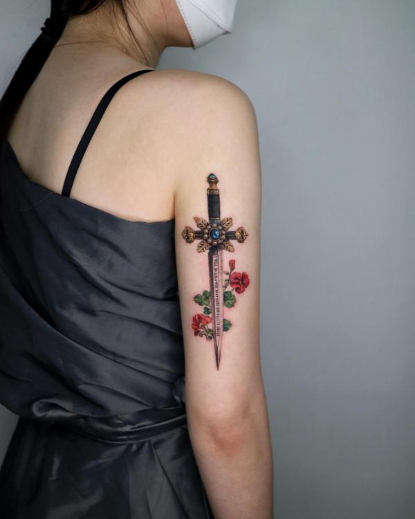 Dagger with flower back of arm tattoo