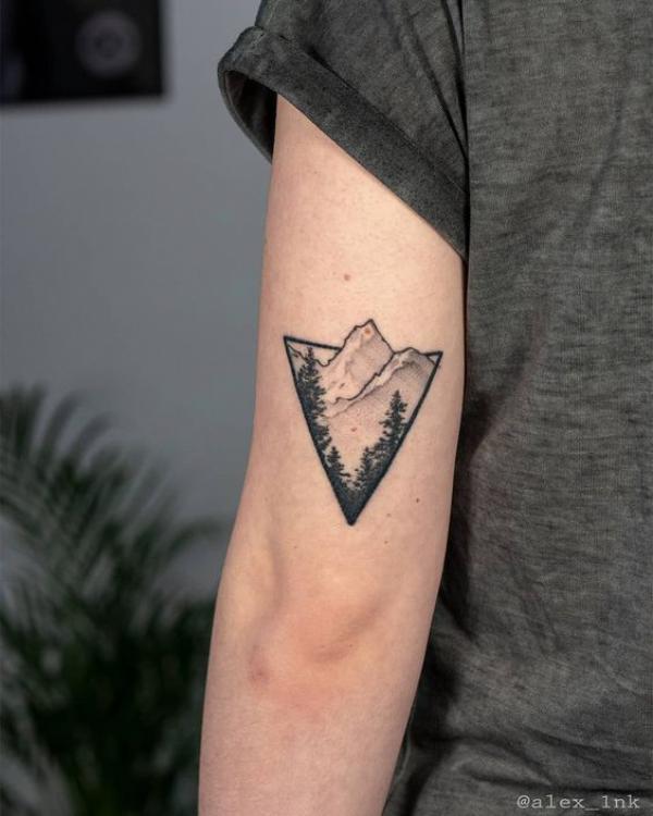 Mountain with tree back of arm tattoo