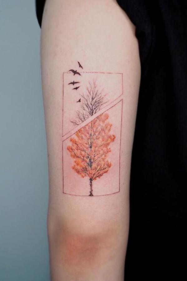 Tree with birds back of arm tattoo