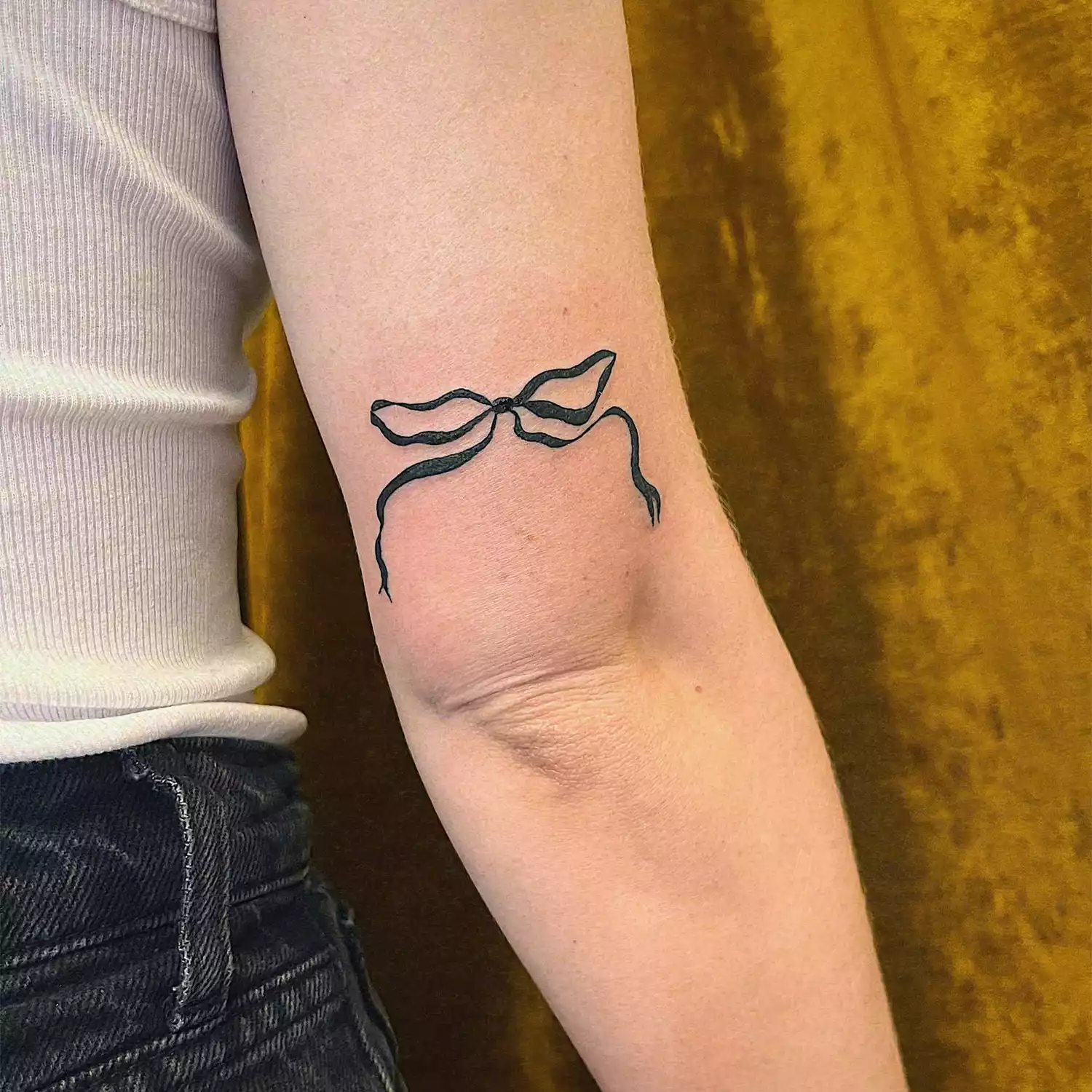 Black bow tattoo