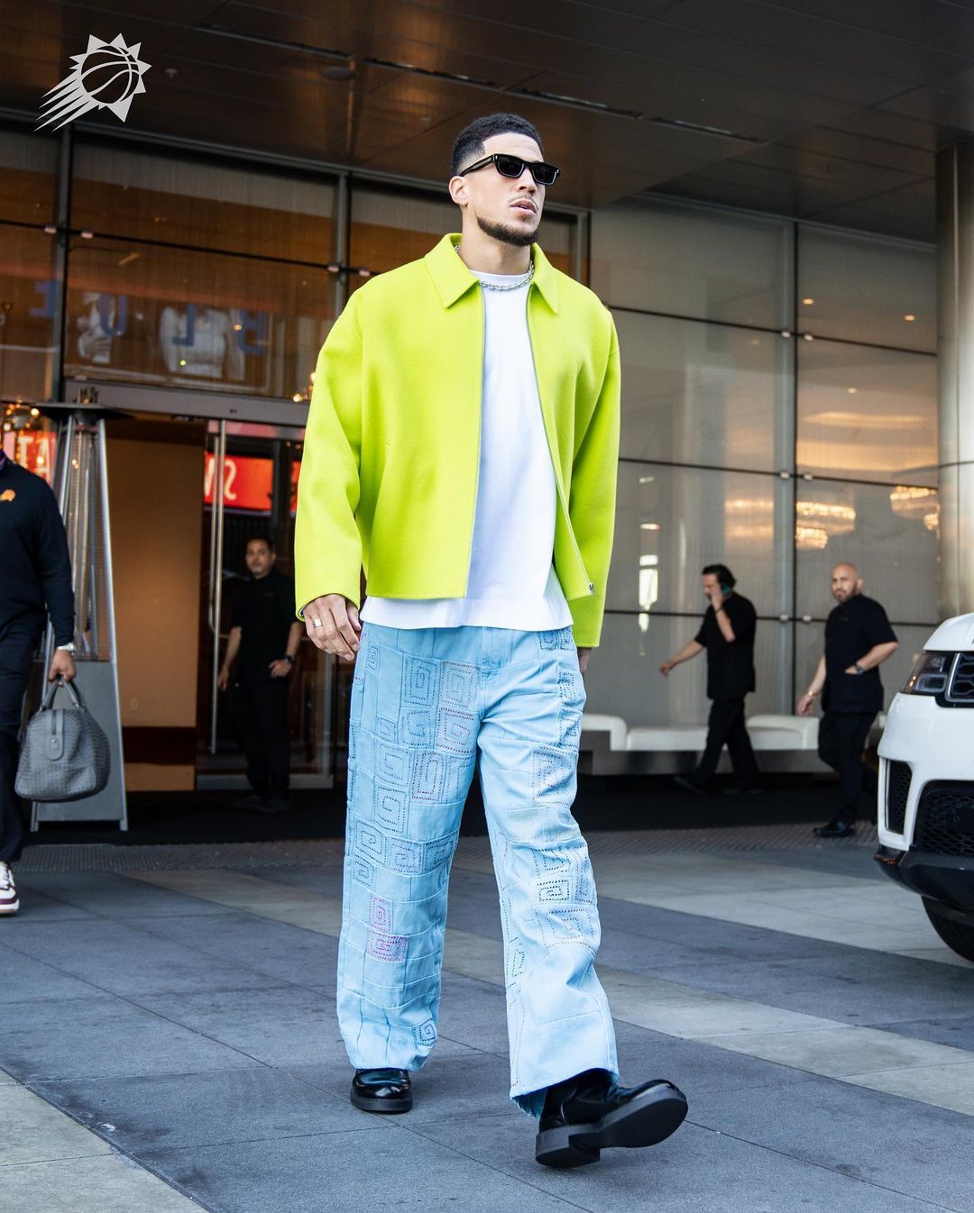 Devin Booker shows off a fashionable style choice with his bright colored outfit.