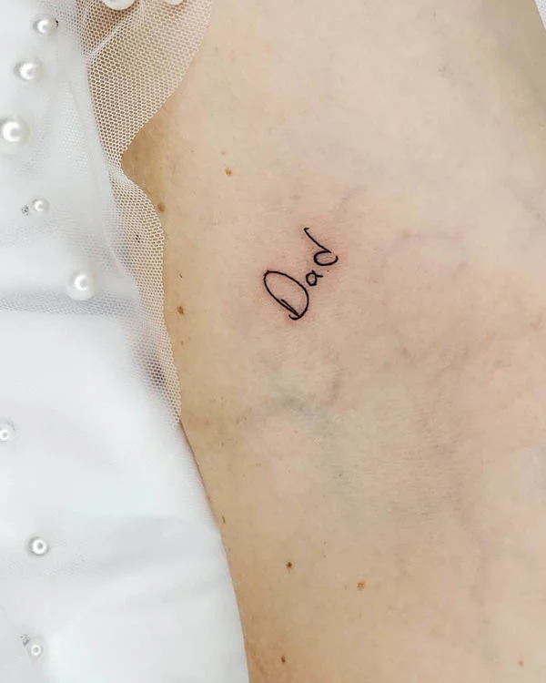Dad - one-word tattoo by @tinytattoos_feathertouch