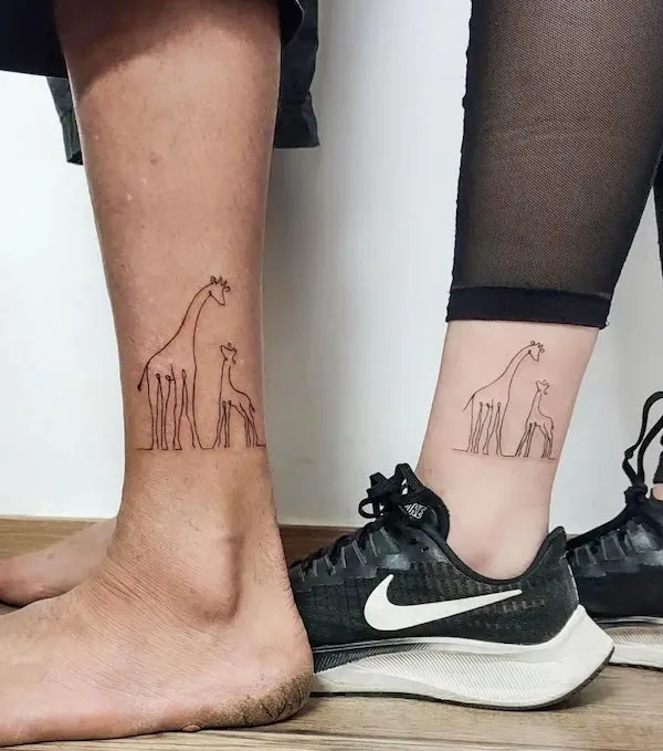 A pair of giraffe above the ankle by @lulachina.art_.tattoo