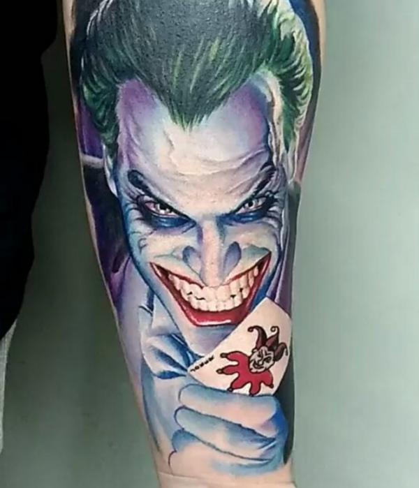 Joker with card tattoo forearm