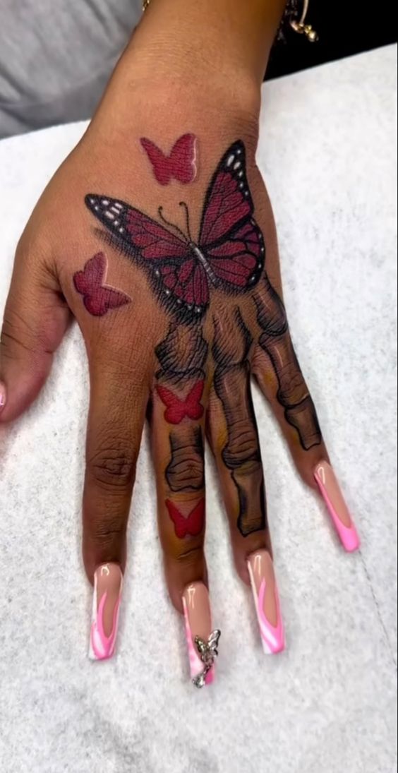 Red butterfly and skeleton hand tattoo