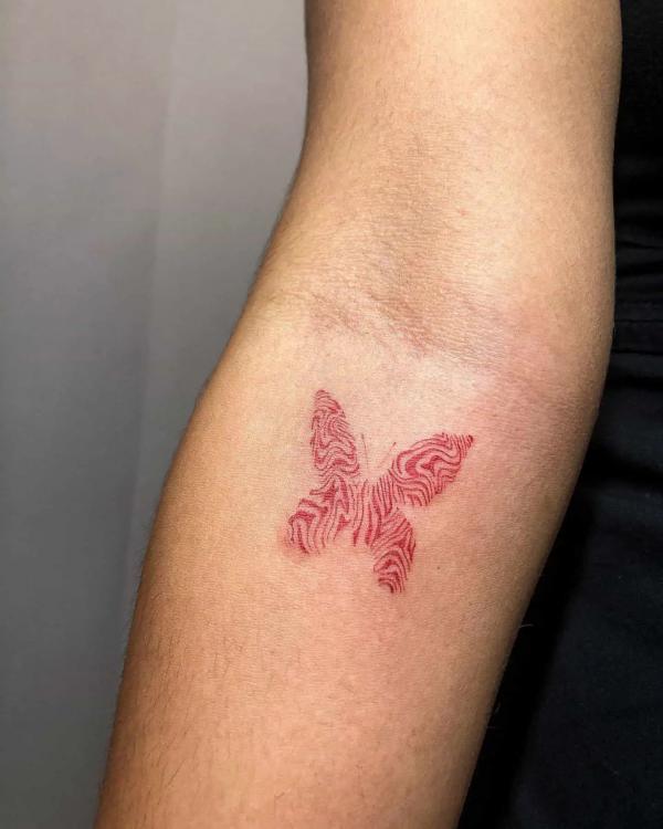 Red fingerprint butterfly tattoo