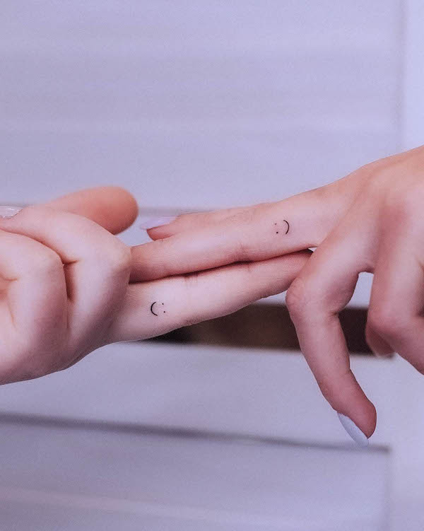 Small smiley face wedding ring tattoos by @tavi_tattoo