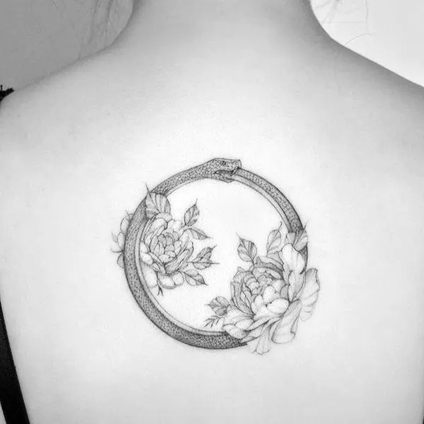 Elegant floral ouroboros tattoo by @marcelabadolatto