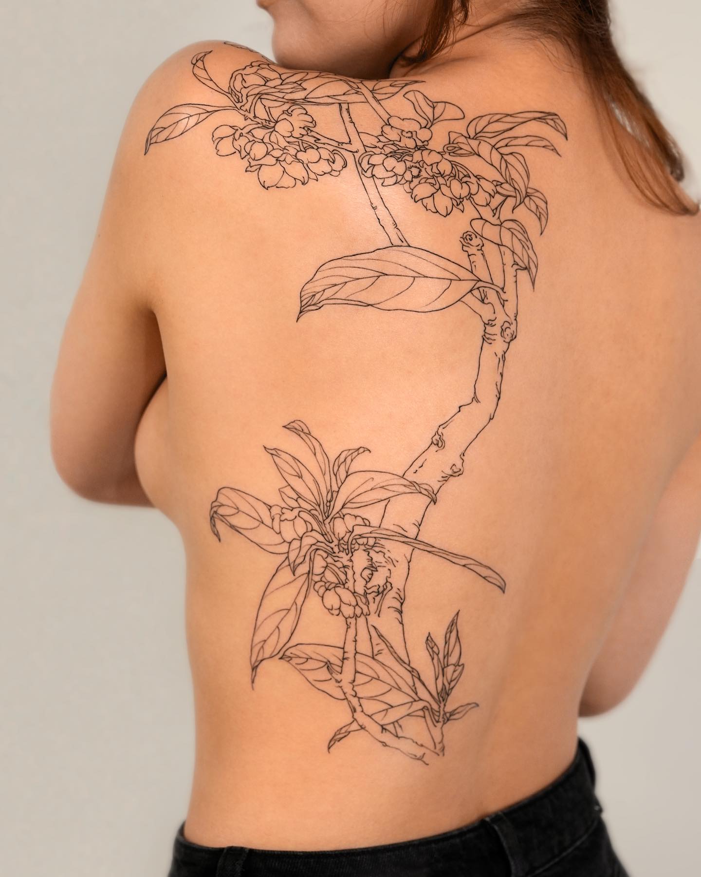 Floral branch tattooed on the back