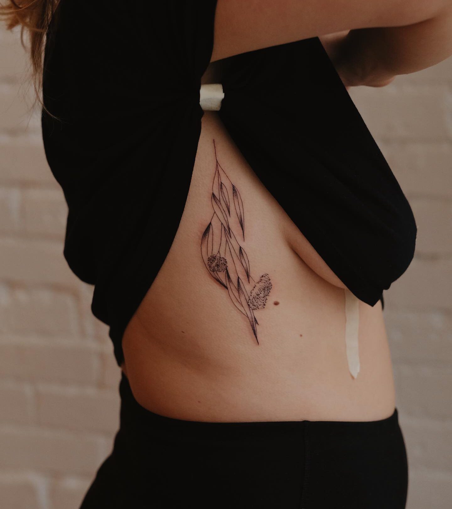 Flowers and leaves tattoo located on the rib,, illustrative style