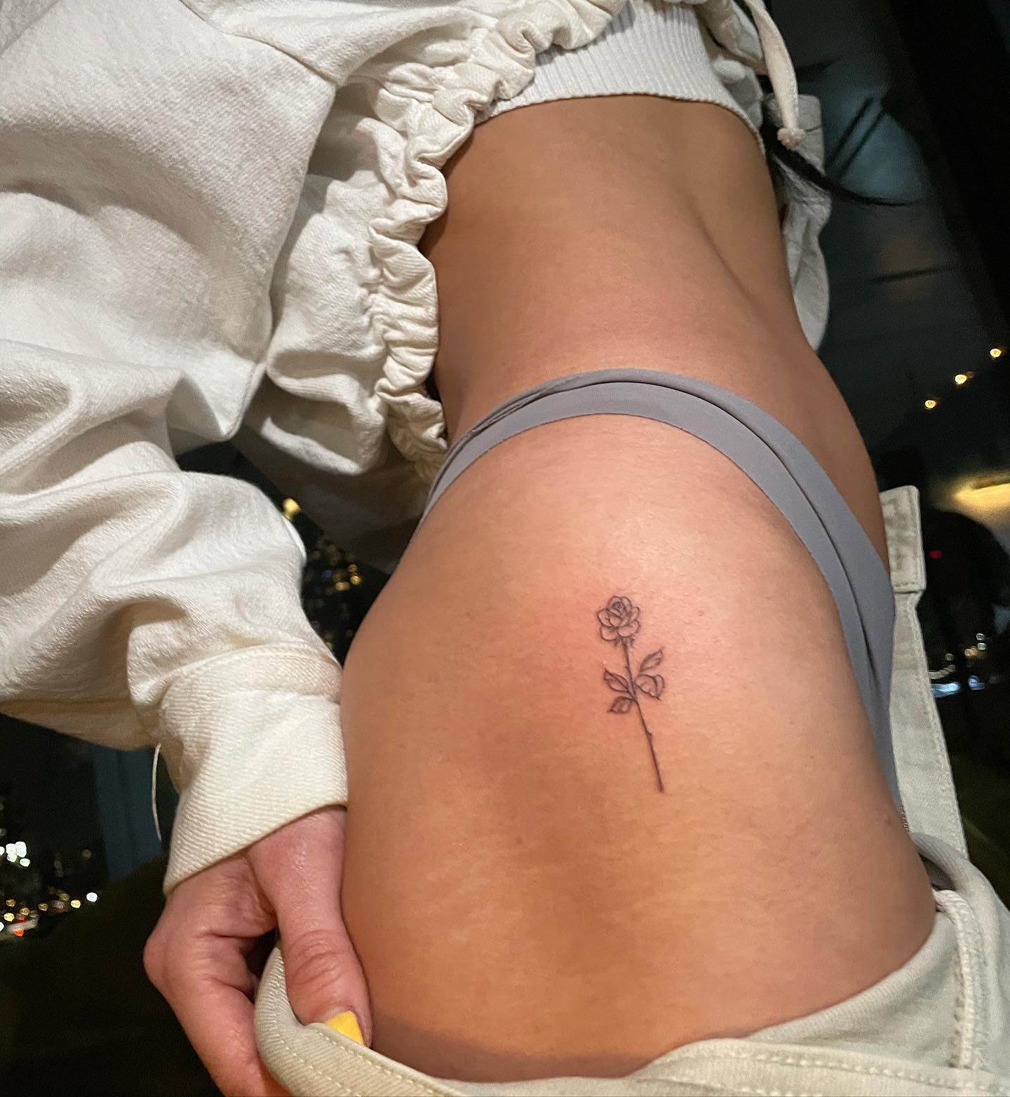 Fine line style rose tattoo on the hip