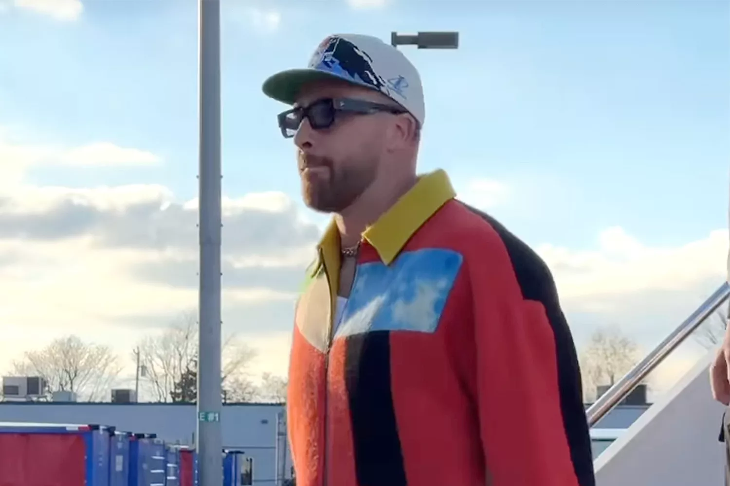 Travis Kelce Arrives in Buffalo in Bold Multi-Colored Jacket and Cavs Baseball Cap Ahead of Chiefs-Bills Matchup