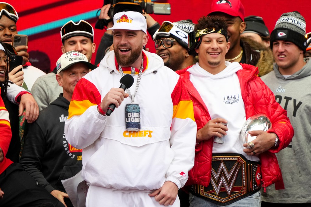 Travis Kelce #87 and Patrick Mahomes #15 of the Kansas City Chiefs celebrate on stage during the Kansas City Chiefs Super Bowl LVII victory parade on February 15, 2023 in Kansas City, Missouri.