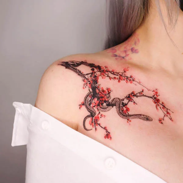 Plum flower and snake collarbone tattoo for women by @kissami_ink