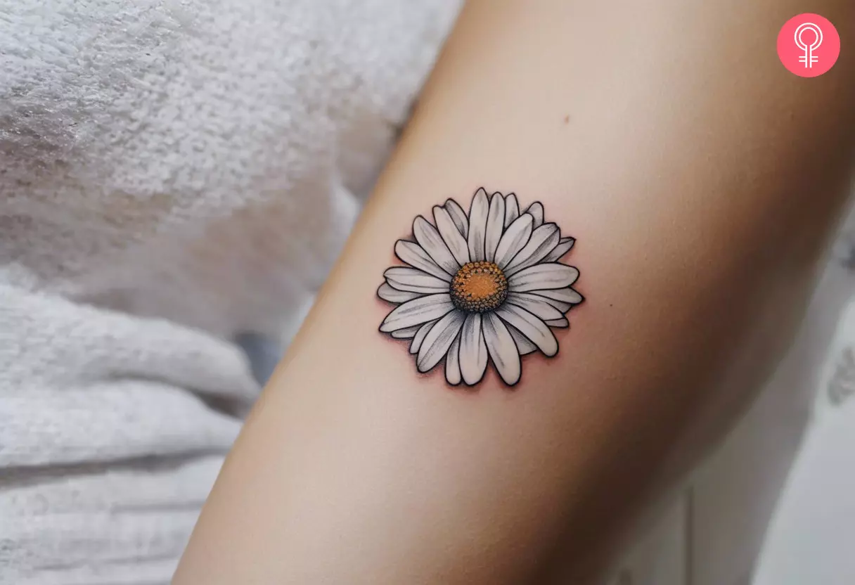 Woman with a realistic daisy tattoo