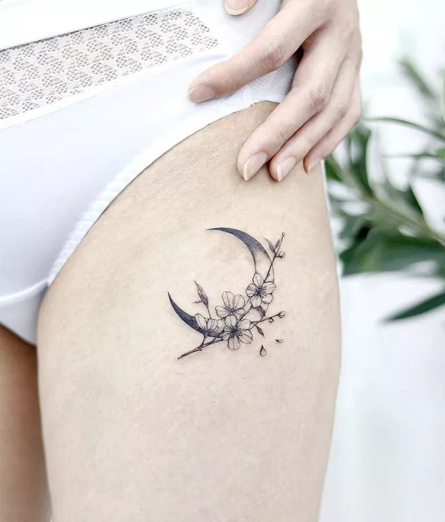 floral crescent moon thigh tattoo