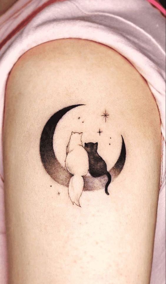 This may contain: a black and white cat sitting on the moon tattoo