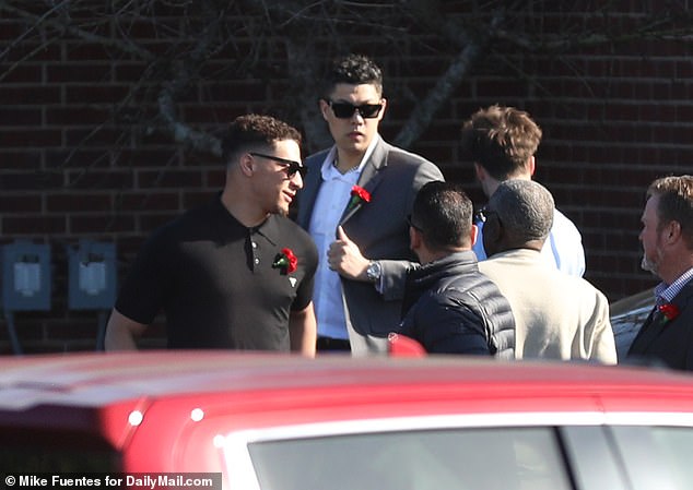 Mahomes, wearing a black polo shirt and a red rose, was spotted with brother Jackson (top)