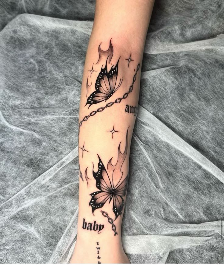 This may contain: a woman's arm with two butterflies on it and the words tattoo written in black ink