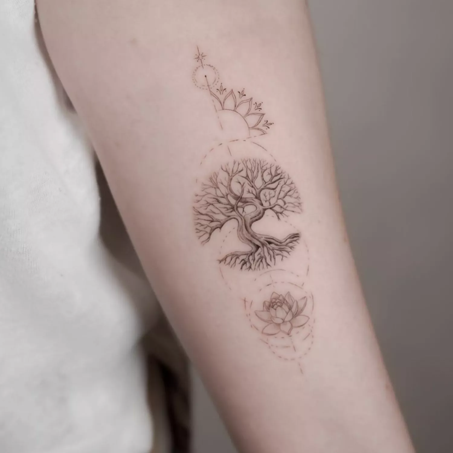 Forearm tree tattoo with zen motifs