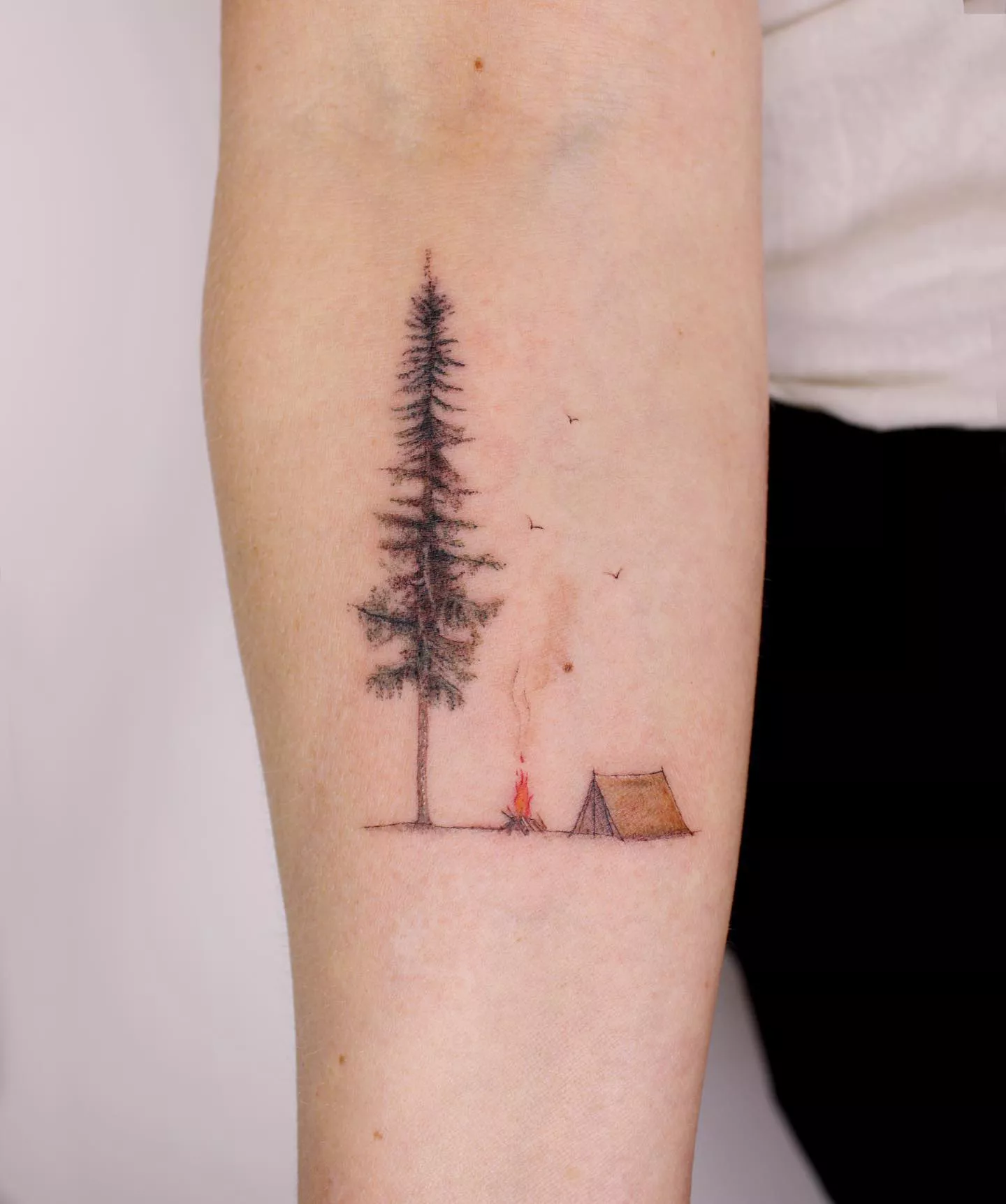 Close up of a forearm with a tree tattoo