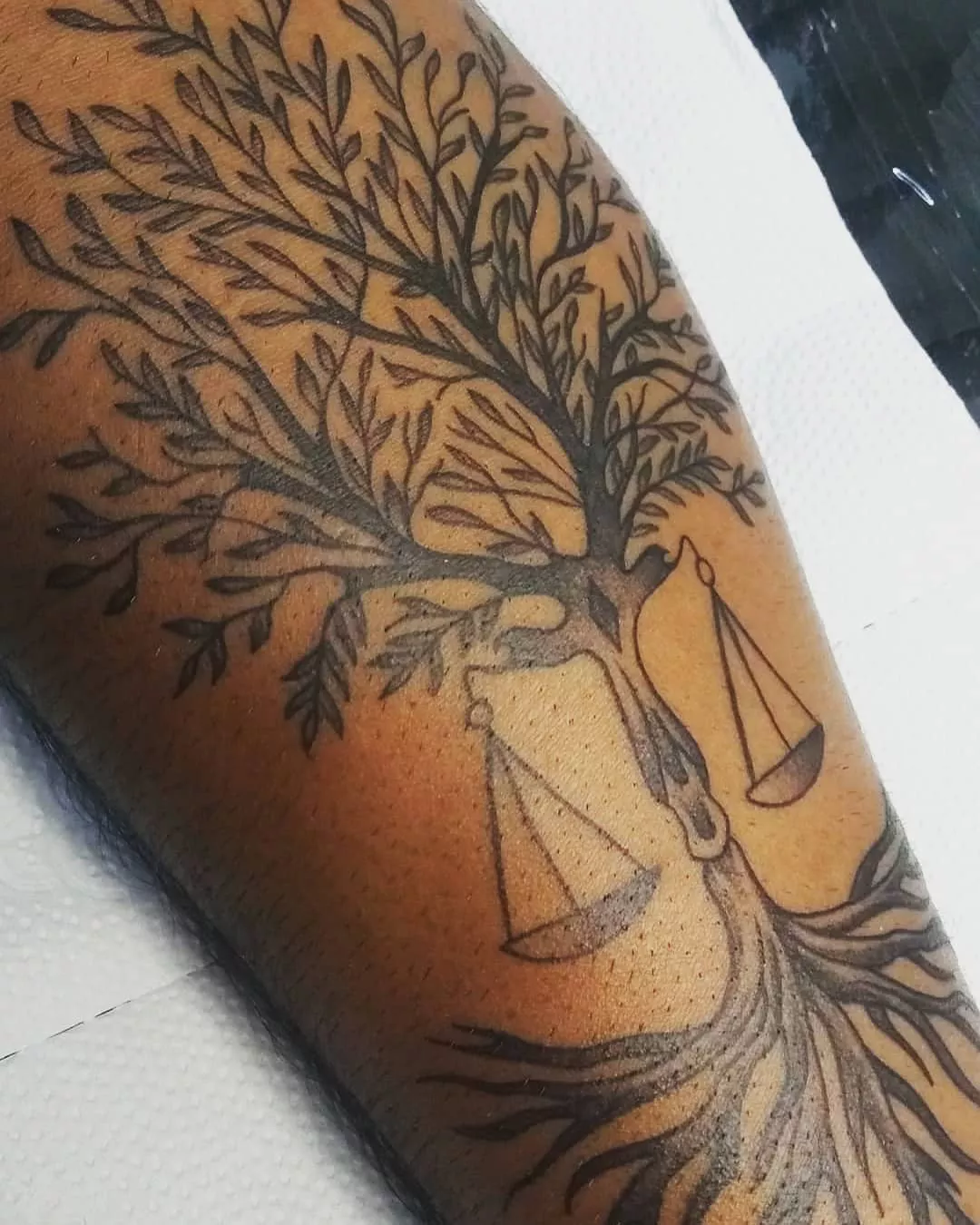 Close up of a tree and scale tattoo