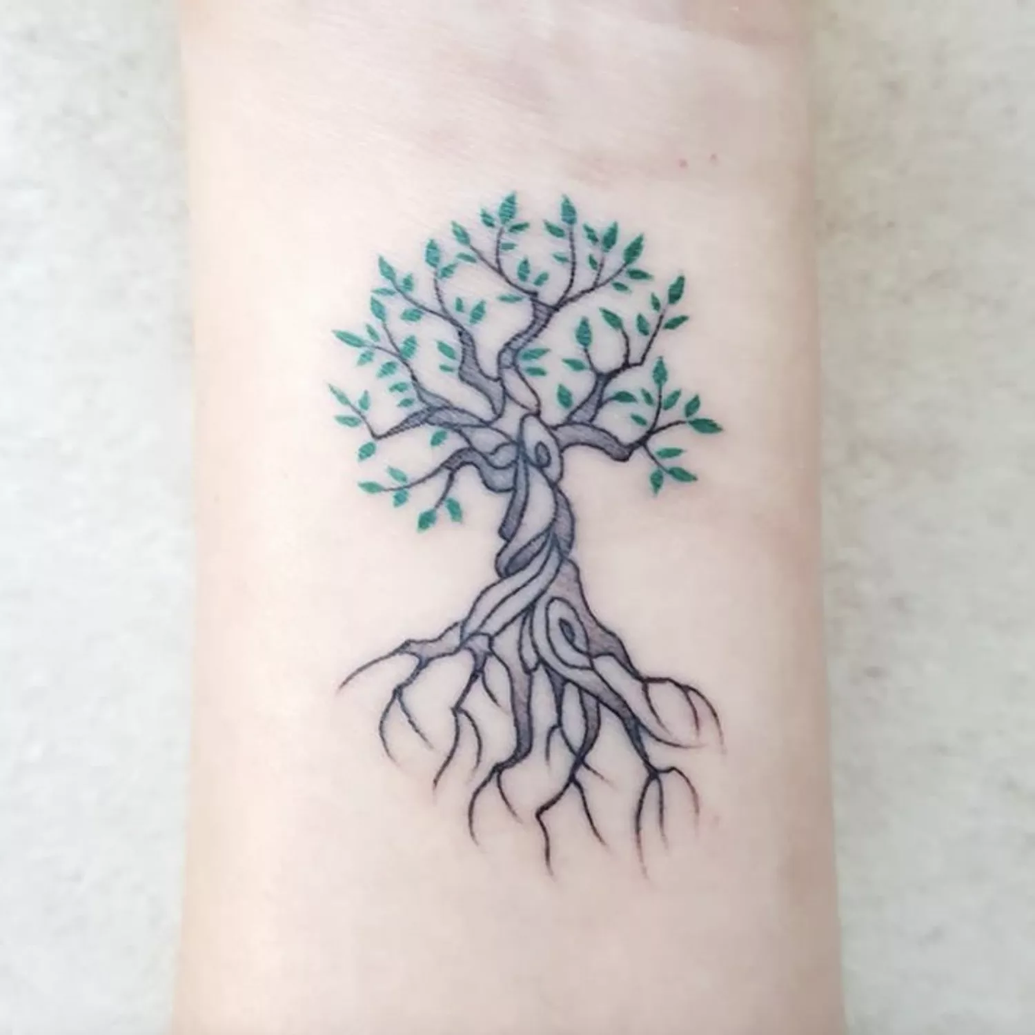 Whimsical tree tattoo on forearm