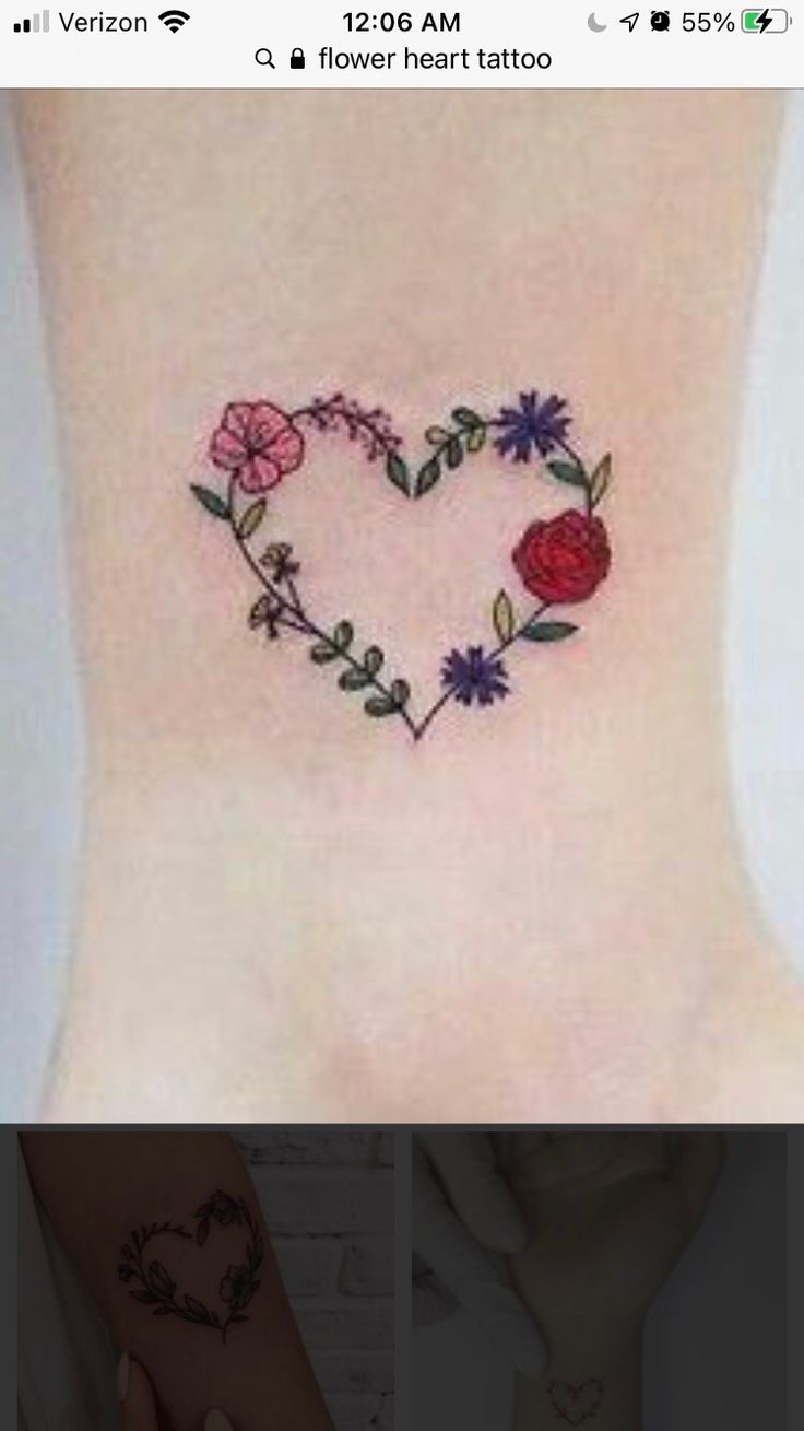 This may contain: a small heart shaped tattoo with flowers on the side of the foot and behind it is a rose