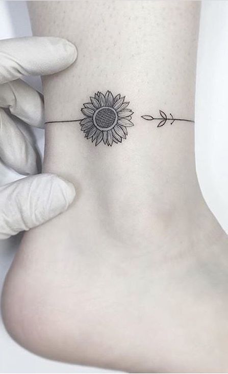 Monochromatic sunflower ankle tattoo, symbolizing optimism and looking towards the future