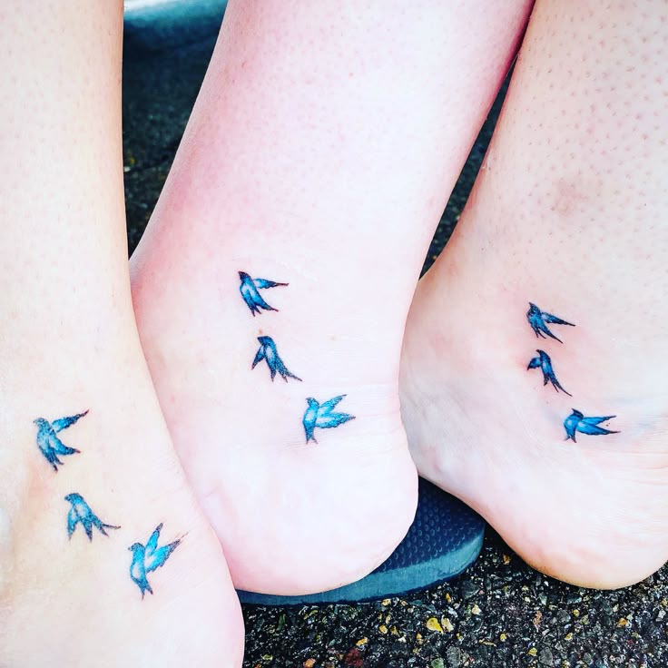 This may contain: two people with blue birds on their feet