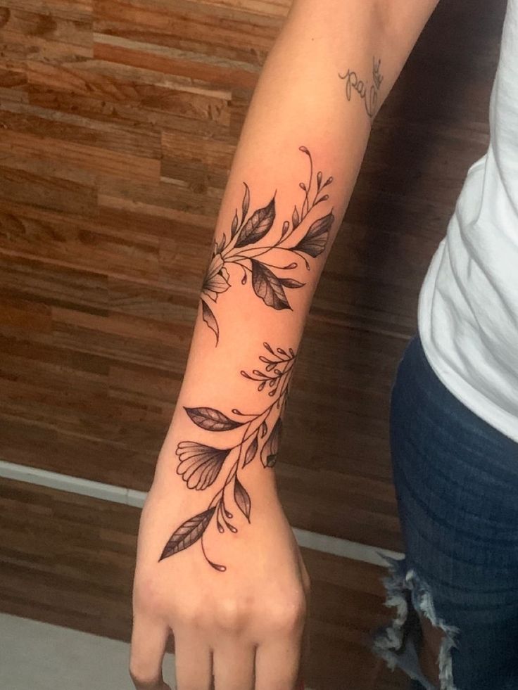 This may contain: a woman's arm with flowers on it and the word love written in cursive writing