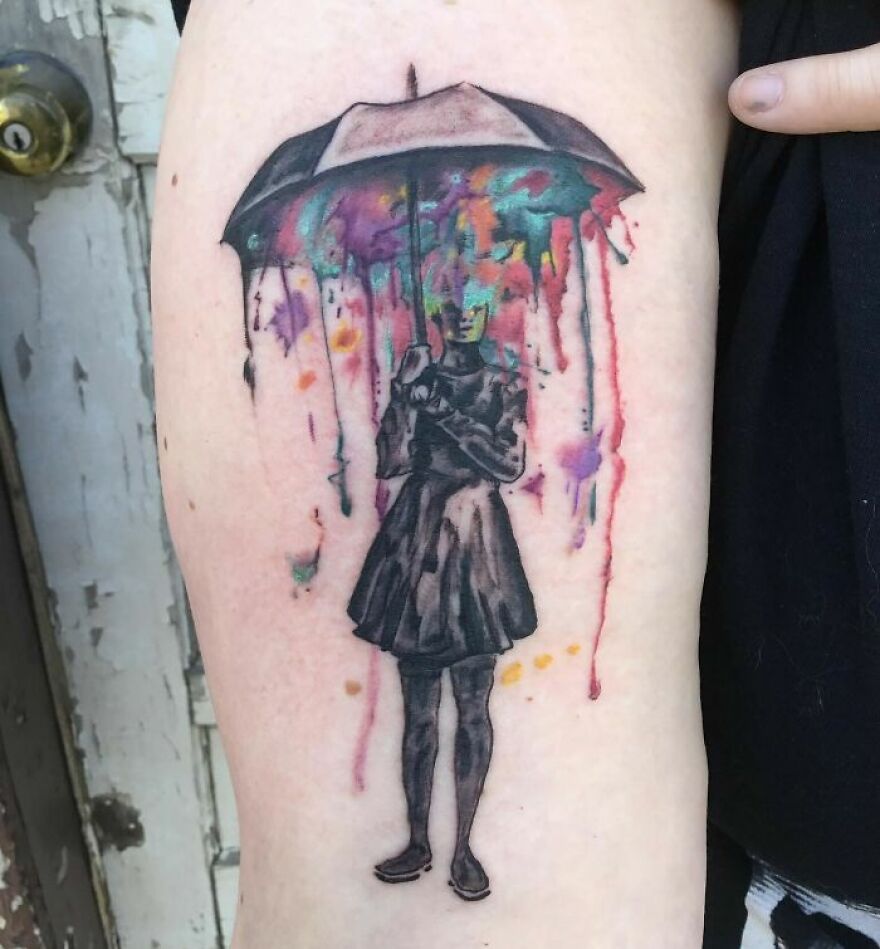 Watercolor tattoo of a person under an umbrella with colorful paint drips forming a vibrant background. Watercolor tattoo of a person under an umbrella with colorful paint drips forming a vibrant background.