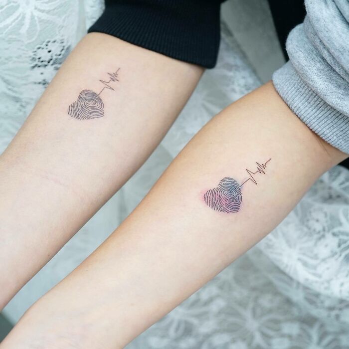Matching family tattoos with heart-shaped fingerprint design symbolizing bonds. Matching family tattoos with heart-shaped fingerprint design symbolizing bonds.