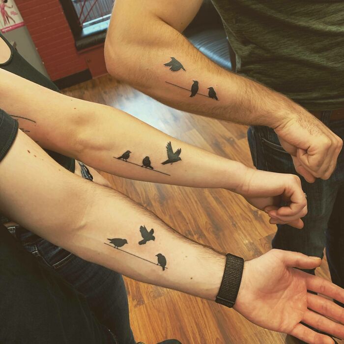 Three arms with matching bird tattoos symbolizing family bonds. Three arms with matching bird tattoos symbolizing family bonds.