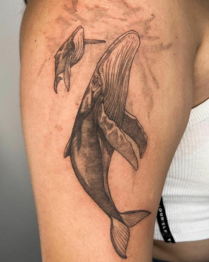 Family tattoo featuring a parent and baby whale, symbolizing unbreakable bonds and unity. Family tattoo featuring a parent and baby whale, symbolizing unbreakable bonds and unity.