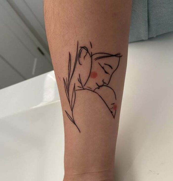Simple line art tattoo depicting family bonds, featuring an abstract figure of a mother holding a child, on an arm. Simple line art tattoo depicting family bonds, featuring an abstract figure of a mother holding a child, on an arm.