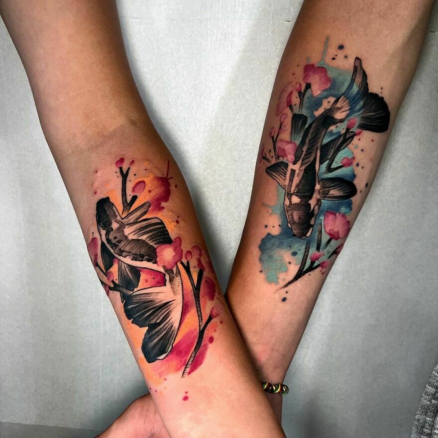 Two forearms with beautiful watercolor tattoos of koi fish and cherry blossoms. Two forearms with beautiful watercolor tattoos of koi fish and cherry blossoms.