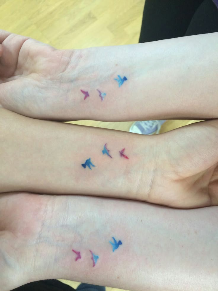This may contain: two people with matching tattoos on their feet, both have small birds tattooed on them