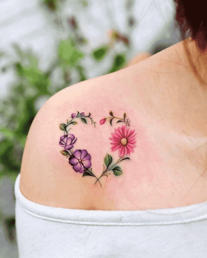 This may contain: a woman's shoulder with flowers in the shape of a heart
