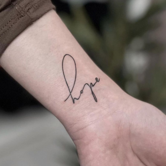 cursive quote tattoo on wrist