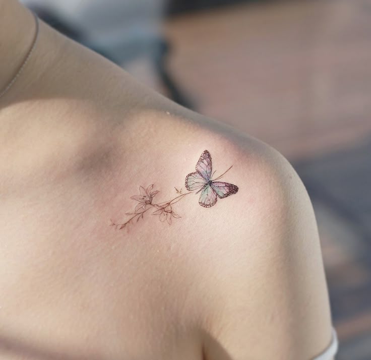 This may contain: a woman with a butterfly tattoo on her shoulder