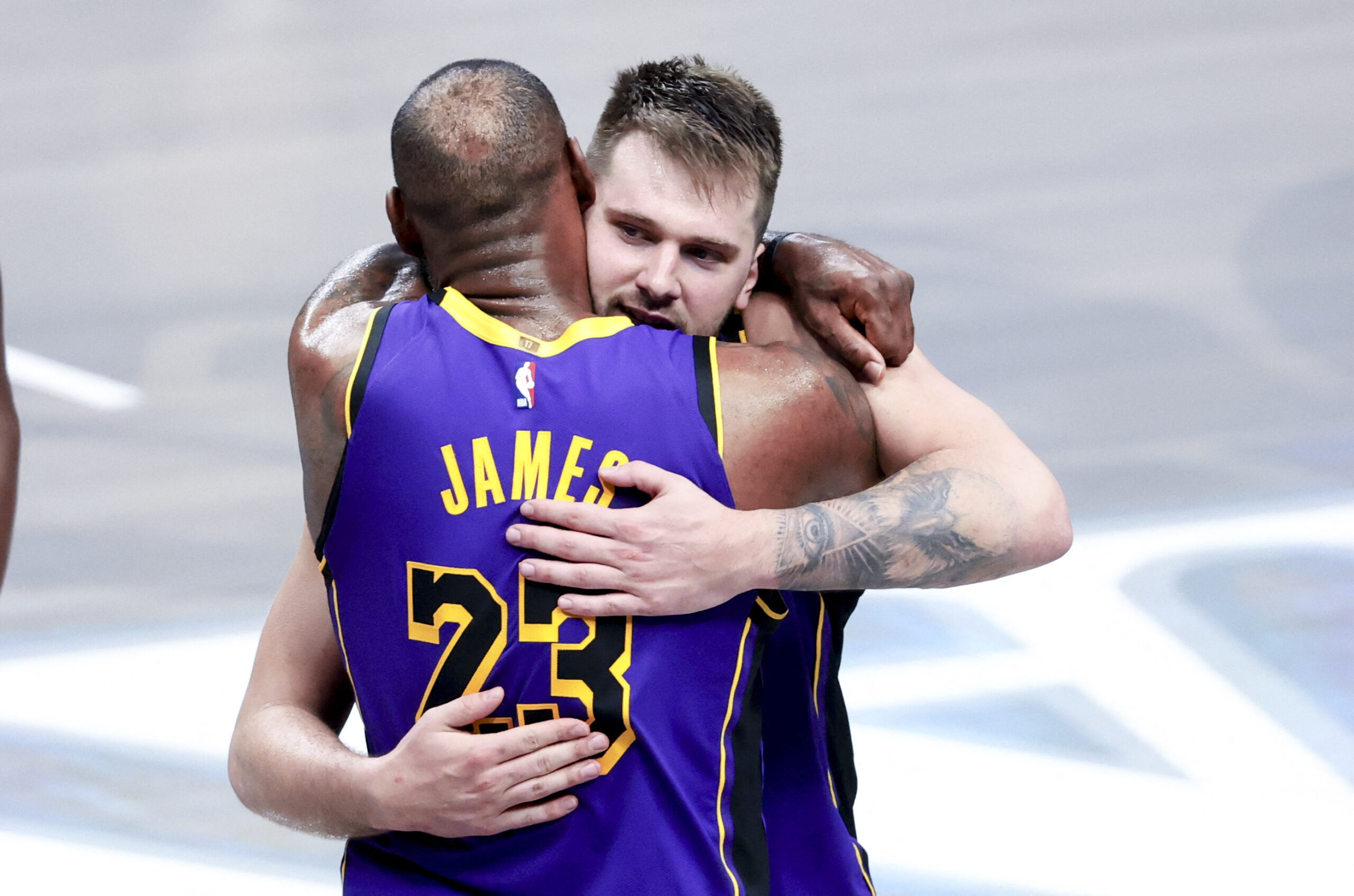 LeBron James and Luka Dončić embracing on the court.