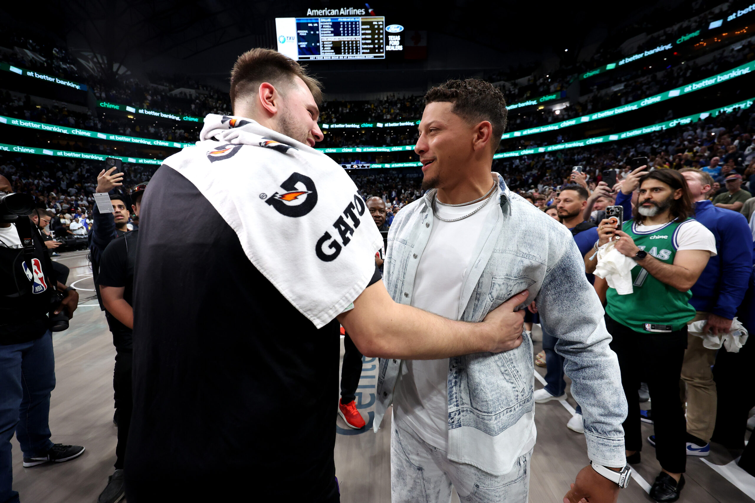Luka Dončić and Patrick Mahomes embracing after a game.