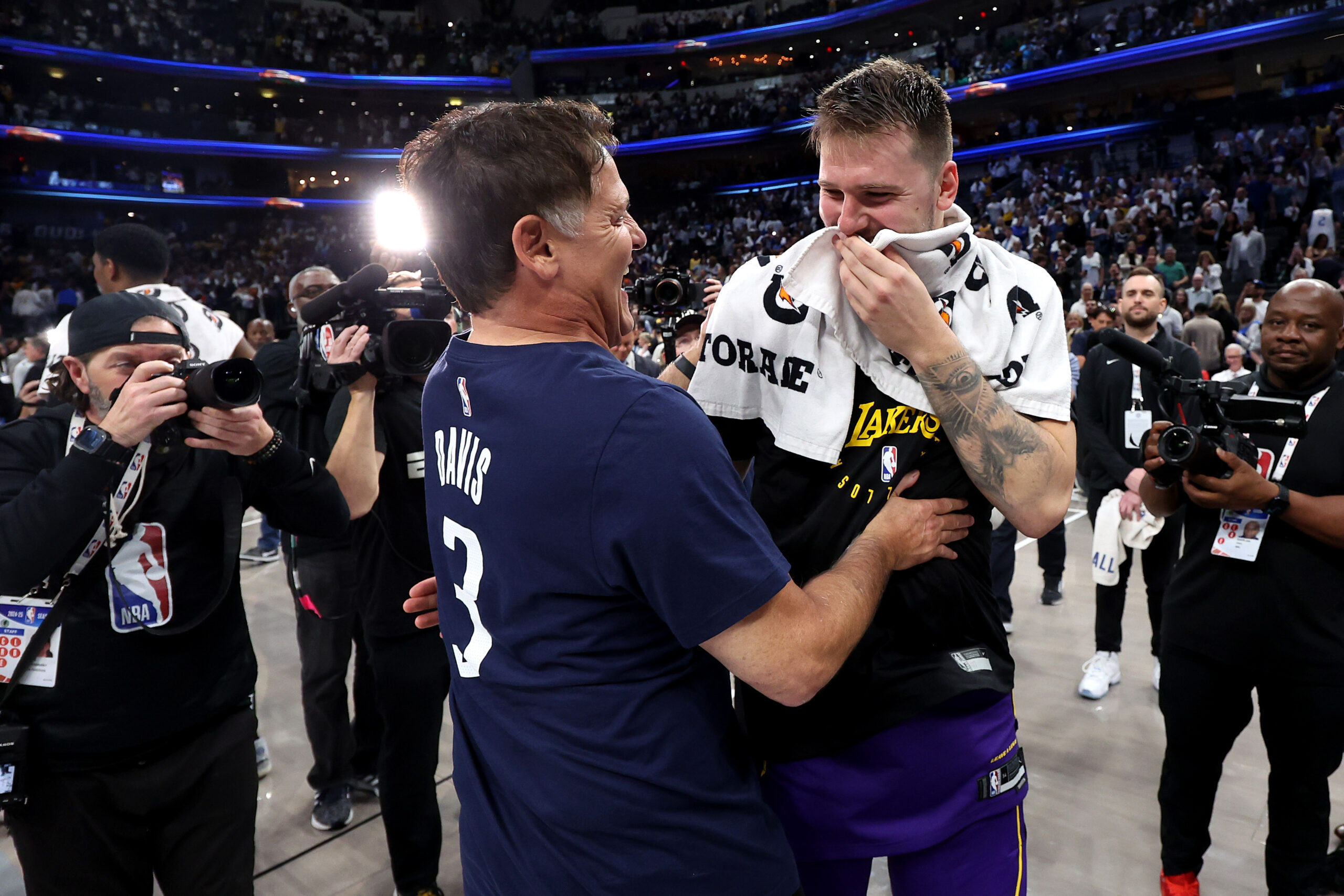 Mark Cuban embracing Luka Doncic after a basketball game.