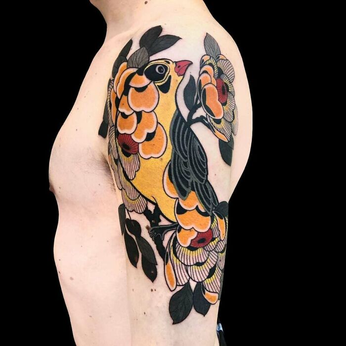 Floral tattoo with a bird design on a man's upper arm, showcasing elegance and beauty. Floral tattoo with a bird design on a man's upper arm, showcasing elegance and beauty.