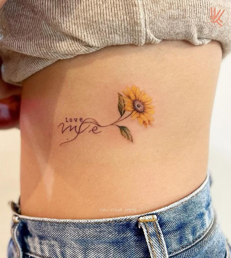 This may contain: a woman with a sunflower tattoo on her stomach